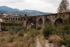 alt Eisenbahn Viadukt im das Berg Resort Dorf von Worochta. Ukraine, Karpaten. foto