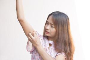 asiatisch Frau haben juckend Haut auf Arm foto
