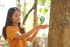Konzept von Speichern das Welt asiatisch Frau halten ein klein Baum foto