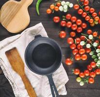 runde Bratpfanne aus Gusseisen und reife rote Kirschtomaten foto