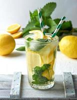 sommererfrischungsgetränk limonade mit zitronen, minzblättern, limette in einem glas foto