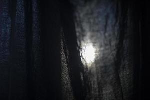 Licht durch Stoff. Vorhang auf Fenster. schwarz Stoff Textur auf Lumen. foto