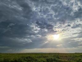 schöne aussicht auf sonnenstrahlen mit einigen linseneffekten und wolken am blauen himmel foto