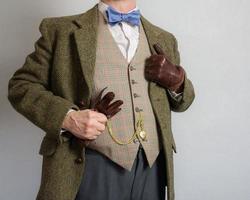 Mann im Tweed passen halten Leder Handschuhe. Jahrgang Mode von Englisch Gentleman foto