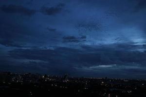 dunkel Blau Wolke mit Weiß Licht Himmel Hintergrund und Stadt Licht Mitternacht Abend Zeit foto