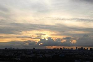 Sonnenuntergang dunkel Blau Wolke mit Weiß golden Licht Himmel Hintergrund und Stadt Licht Mitternacht Abend Zeit foto