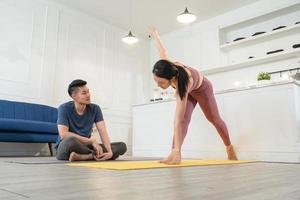 asiatisch Freund suchen beim seine Freundin üben Yoga auf Übung Matte foto