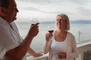 reifes Paar, das draußen Wein trinkt foto