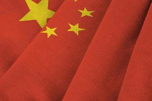 china-flagge mit großen falten, die nah oben unter dem studiolicht drinnen winken. die offiziellen symbole und farben im banner foto