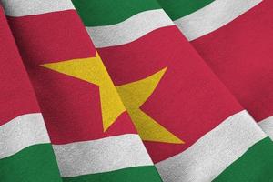 suriname-flagge mit großen falten, die unter dem studiolicht im innenbereich wehen. die offiziellen symbole und farben im banner foto