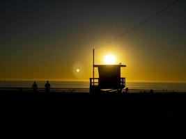 ein Rettungsschwimmerturm mit einem goldenen Sonnenuntergang foto