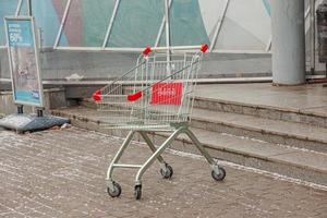 ein leeren Wagen von das Supermarkt im Vorderseite von das Eingang zu das speichern. foto