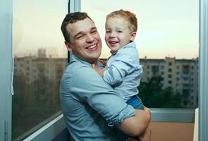 Vater und Sohn lächeln auf einem Balkon foto