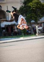 Mann, der akrobatische Tricks in einer Stadtstraße tut foto