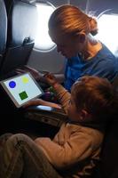 junge Mutter und Sohn reisen in einem Flugzeug foto