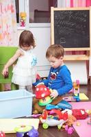 Kinder spielen zu Hause mit Spielzeug foto