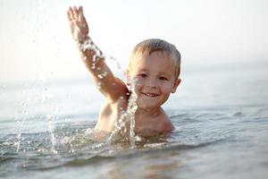 Junge schwimmt draußen foto