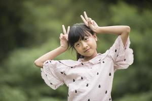 Porträt eines kleinen asiatischen Mädchens, das mit der Kamera spielerisch ist