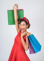 schöne asiatische Frau, die farbige Einkaufstaschen hält foto