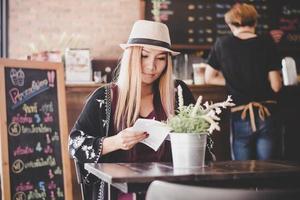 glückliche Geschäftsfrau, die Buch liest, während sie im Café entspannt