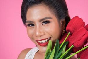 Porträt einer schönen Frau mit Strauß roter Tulpenblumen foto