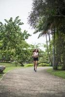 junge sportliche Frau, die am Park läuft foto