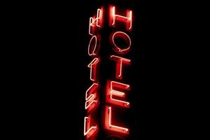 Hotel Neon- rot Zeichen isoliert auf schwarz foto