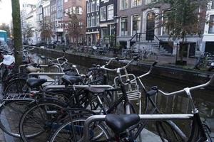 Fahrräder in Amsterdamer Grachtenstraßen foto