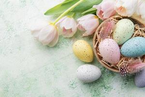 Schüssel mit Ostern Eier gemalt Pastell- Farben auf ein Grün hölzern Hintergrund. foto