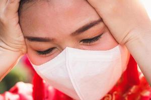 Chinesisch Frau tragen ein cheongsam tragen ein Weiß Maske Abdeckung das Nase und Mund. zu verhindern das Coronavirus. Konzept von Krankheit Verhütung. Neu Jahr Festival 2020 foto