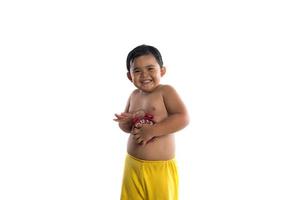 kleiner asiatischer Junge, der eine große rote Uhr hält, lokalisiert auf weißem Hintergrund foto