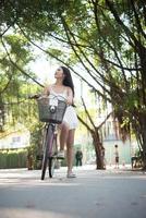 junge schöne Frau, die ein Fahrrad in einem Park reitet foto
