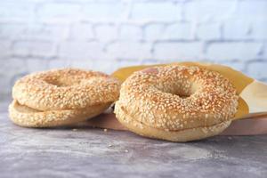 frisches Bagelbrot in einem Papier auf Tisch foto