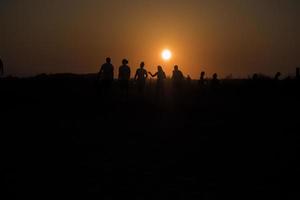 Silhouette von Menschen vor dem Sonnenuntergang