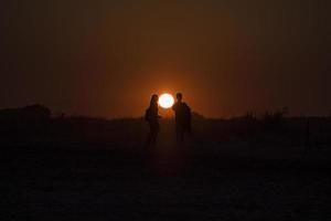 Silhouette von zwei Personen vor dem Sonnenuntergang