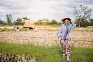 jung ziemlich Farmer Frau Stehen auf Ackerland und inspizieren landwirtschaftlich Pflanzen foto