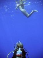 ein Tauchen Taucher Weg während Fotografieren ein Schnorchler von unter Wasser foto