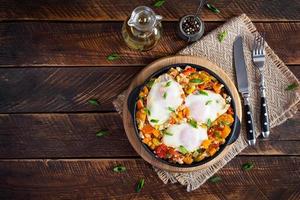 Shakshouka im braten Pfanne. gebraten Eier mit Gemüse, Tomate, Pfeffer, Kürbis und Zwiebel. oben Aussicht foto