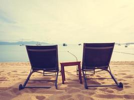 Sonnenschirme und Sonnenliegen am tropischen Strand foto