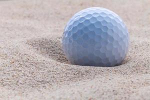 Golfball im Sand foto