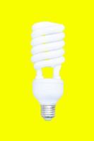 Energie Speichern Glühbirne, fluoreszierend Spiral- Licht Birne isoliert auf Gelb Hintergrund foto