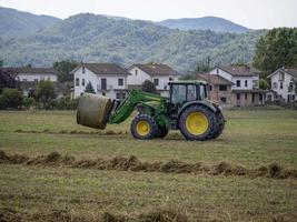Traktor ziehen um Weizen Ball im das Feld foto