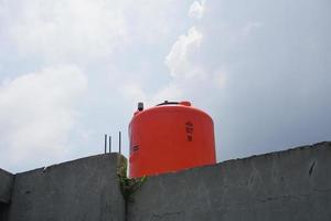 groß Orange Wasser Reservoir auf das Dach von das Haus. foto