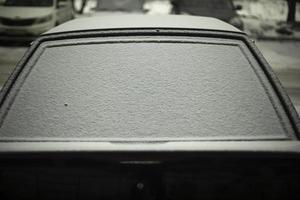 Rückseite Fenster von Auto im Schnee. Schnee durch Wagen. Auto ist geparkt im Winter. foto