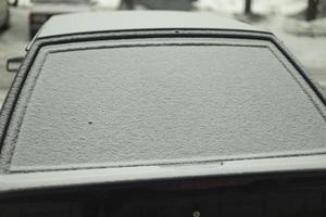 Rückseite Fenster von Auto im Schnee. Schnee durch Wagen. Auto ist geparkt im Winter. foto