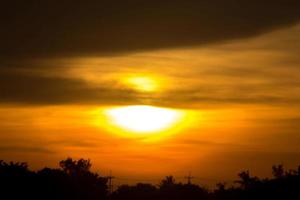 das groß Sonne ist Über zu einstellen im das Abend wie das Himmel ist ein warm und erschreckend Gelb Orange, etwas Natur hat erstellt im ländlich Thailand. foto