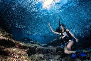 Schöner Latina-Taucher in einem Fischschwarm foto