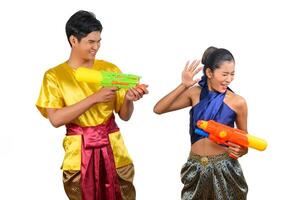 junges paar genießt mit wasserpistole auf songkran festival foto