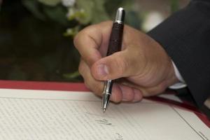 Hand beim Anmelden für die Hochzeit foto