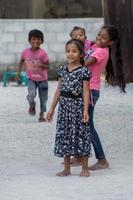 Kondey, Malediven - 12. März 2014 - Kinder und Menschen auf der Straße vor dem Abendgebet foto